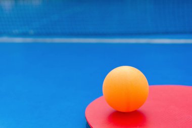 pingpong raket ve top ve bir mavi pingpong tablo net