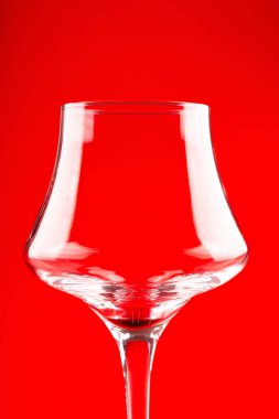 Cam bardak şarap için kırmızı arka plan üzerinde kapat