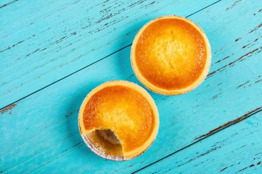 Üstten Görünüm taze cocknut tarts ve mavi ahşap arka plan üzerinde bir ısırık ile yakın çekim