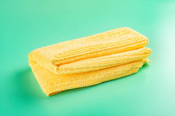 折叠的黄色毛巾在绿色背景 — 图库照片