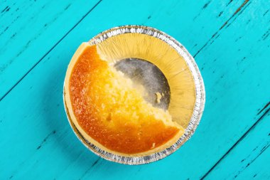 Üstten Görünüm taze cocknut tart bir ısırık ile mavi ahşap arka plan üzerinde kapat