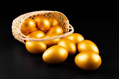 altın yumurta siyah arka plan üzerine bir sepeti yayıyoruz