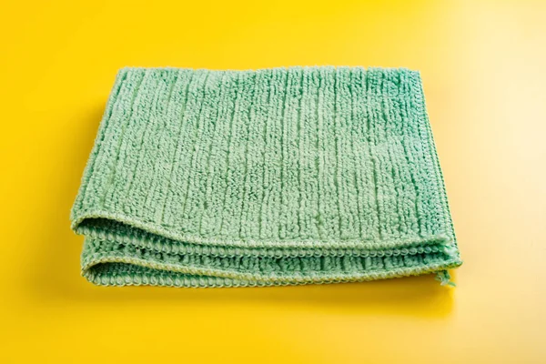 折叠的绿色毛巾在黄色背景 — 图库照片