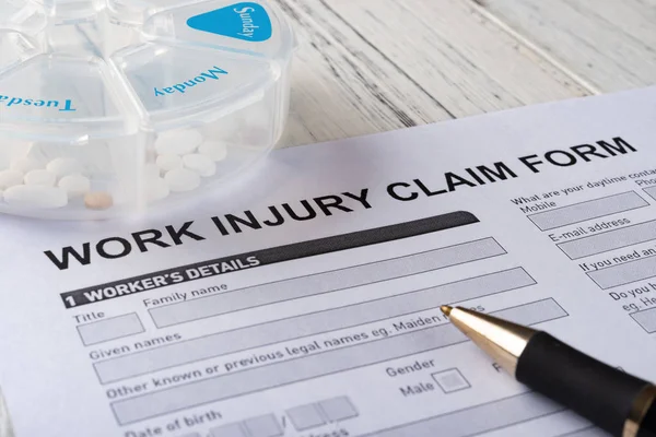 Work Injury Claim Form Box Pills Pen Medical Insurance Concept — Stock Photo, Image