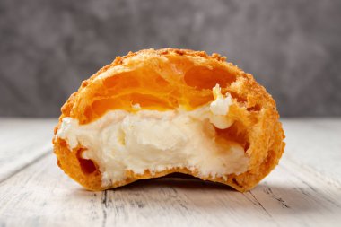 Beyaz ahşap masada bir ısırık ile tatlı puf