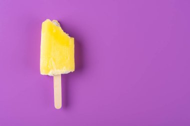 mor bir arka planda bazı ısırıklar ile sarı dondurma