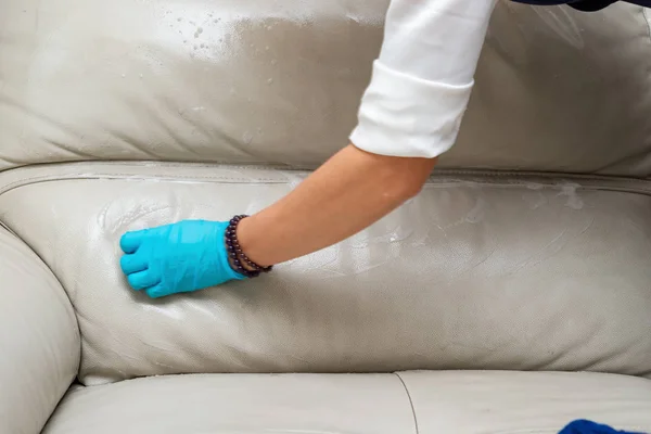 石鹸のスポンジと革のソファーをクリーニングする女性 — ストック写真