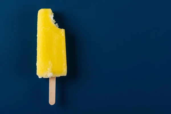 Gele Popsicle Met Een Beet Een Marineblauwe Achtergrond — Stockfoto