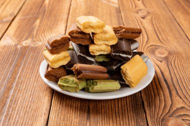 yan görünüm ahşap bir masa üzerinde kırık çok renkli sandviç çerezleri