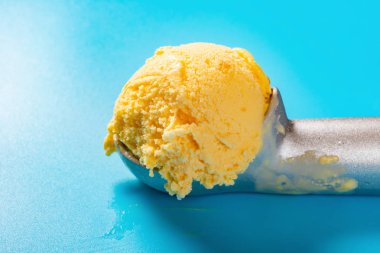 mavi arka plan yakından mango lezzet dondurma topu ile kaşık