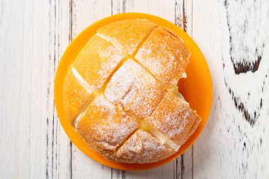 ahşap masada bir ısırık ile içinde krema ile üst görünüm ekmek