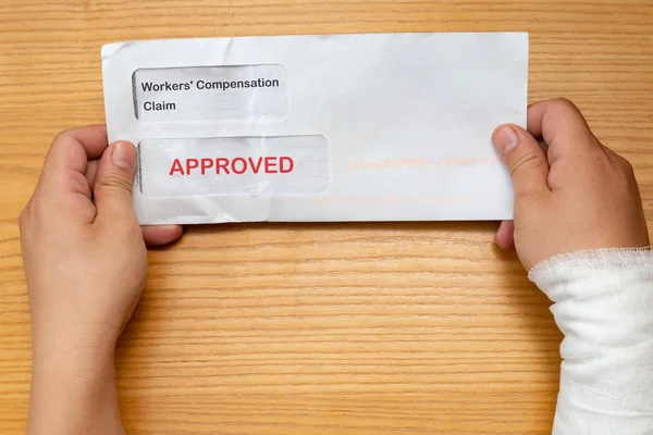 Wrapped Hand Holding Envelope Workers Compensation Claim Result Approved Removeable — Stock Photo, Image