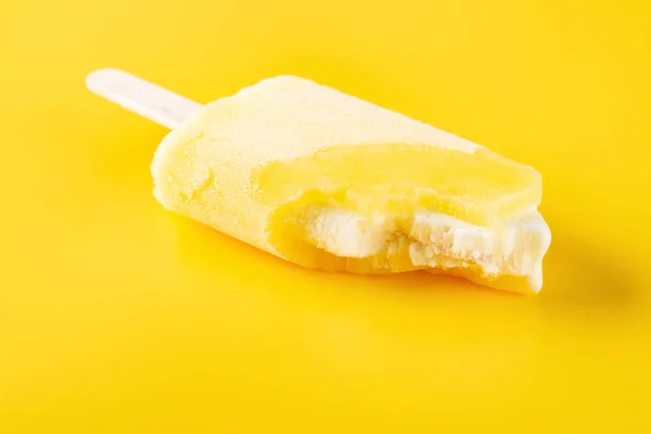 侧视图黄色冰棒与咬在黄色背景 — 图库照片