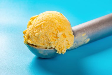 mavi arka plan yakından mango lezzet dondurma topu ile kaşık