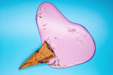 üst görünümü lila dondurma koni mavi arka plan üzerinde erime