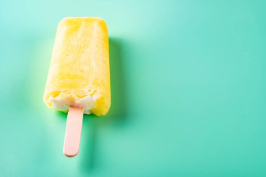 yan görünüm sarı popsicle açık yeşil arka plan üzerinde