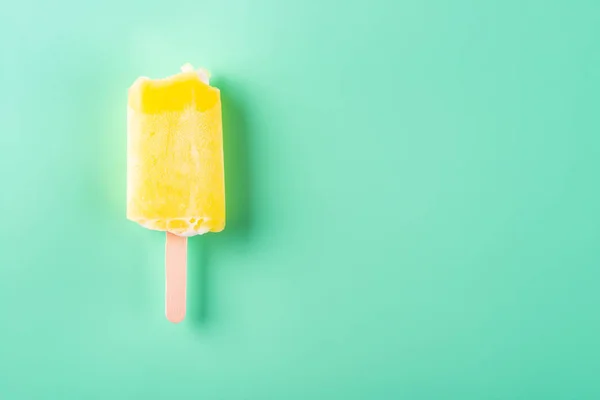 Gele Popsicle Met Aantal Van Bijt Een Lichtgroene Achtergrond — Stockfoto