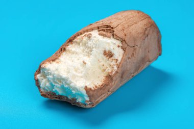 bazı ısırıklar ile mavi arka plan üzerinde çikolata dış ile dondurma rulo