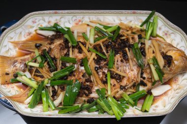 Bütün balık buğulama taze otlar soğan ve sos ile kaplı