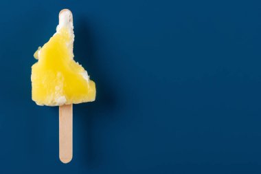 mavi bir arka plan üzerinde yarım yenen sarı buzlu şeker