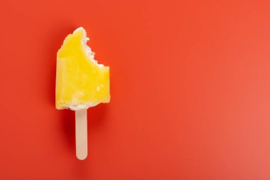 turuncu bir arka plan üzerinde ısırıklar bir çift ile sarı popsicle