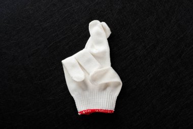 siyah arka plan üzerinde çapraz parmak hareketi ile beyaz eldiven