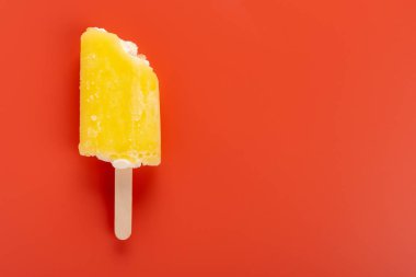 turuncu bir arka plan üzerinde ısırıklar bir çift ile sarı popsicle