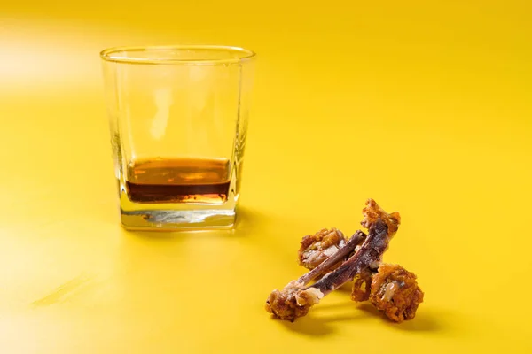 骨头的油炸鸡鼓棒和翅膀与杯几乎完成可乐在黄色背景 — 图库照片