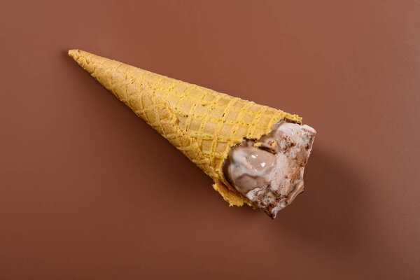 вид сверху кофе и шоколадное мороженое рожок с некоторыми укусами на коричневом фоне
