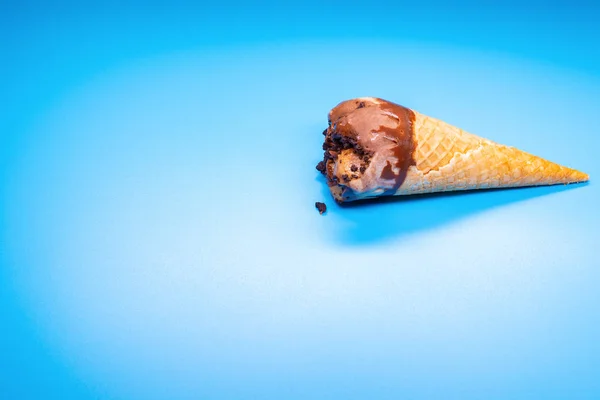 coffee flavor ice cream cone starts melting on a blue background