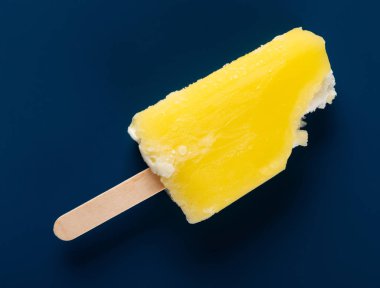 koyu mavi arka planda bazı ısırıklar ile sarı dondurma