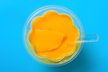 mavi bir arka plan üzerinde bir kaşık ile üst görünüm ev yapımı mango lezzet puding
