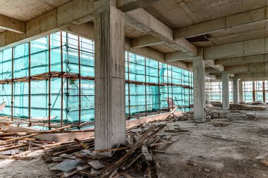koruma iskelesi ve örgü lüzuntuzuna sahip bir unfinshed binanın içinde