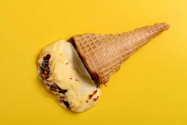 top view mango flavor ice cream cone with peanut melted on yellow background