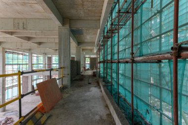 koruma iskelesi ve örgü lüzuntuzuna sahip bir unfinshed binanın içinde