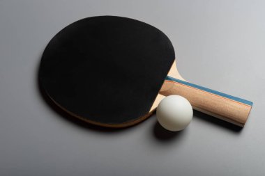 gri bir arka plan üzerinde siyah pingpong raket ve top