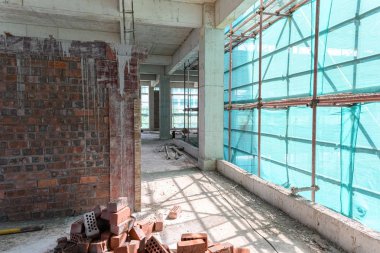 koruma iskelesi ve örgü lüzuntuzuna sahip bir unfinshed binanın içinde