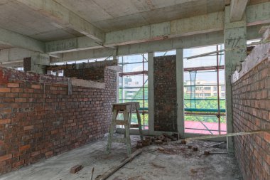 koruma iskelesi ve örgü çevrili bitmemiş bir binanın içinde