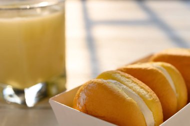 güneşli bir sabah soya sütü fincan ile krem dolum ile yan görünüm kek