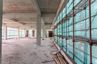 koruma iskelesi ve örgü çevreleyen ile bitmemiş bir binanın içinde