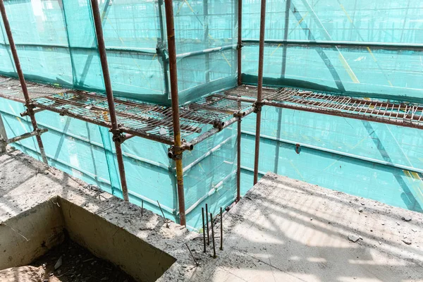 保護足場と網が囲まれた未完成の建物の中 — ストック写真