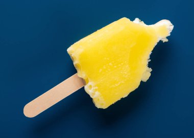 yarım koyu mavi bir arka plan üzerinde sarı buzlu dondurma yemiş