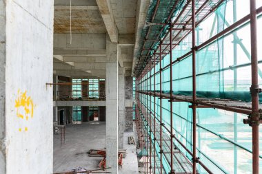 koruma iskelesi ve örgü çevrili bitmemiş bir binanın içinde