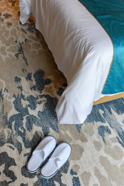 Bir Yatağın Yanındaki Halıda Beyaz Terlikler — Stok fotoğraf