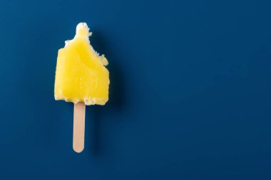 yarım koyu mavi bir arka plan üzerinde sarı buzlu dondurma yemiş