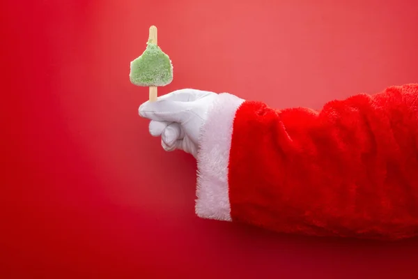 Święty Mikołaj Trzyma Pół Zjedzoną Zieloną Fasolę Lodowisku Przed Czerwonym — Zdjęcie stockowe