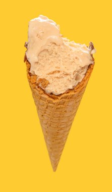 Bakış açısı, sütlü çay aromalı dondurma külahı ve sarı arka planda ısırıklar.