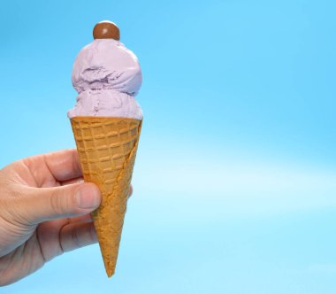 Elinde taze patates dondurması ve üstünde çikolata şekeri olan bir el.