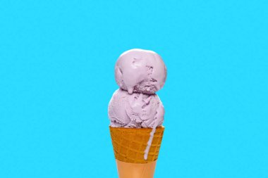 Tatlı patatesli dondurma külahı mavi arka planda erimeye başlar.