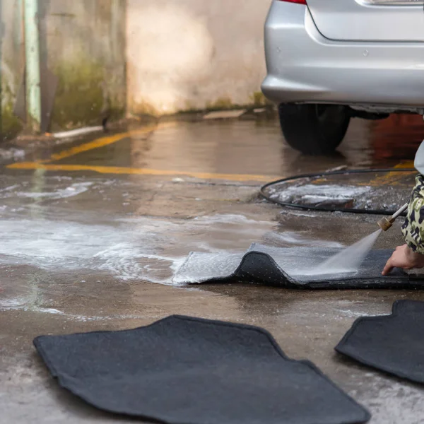 washing carpets for a car with soapy water
